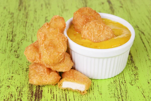 Kipnuggets met saus op tabel close-up — Stockfoto