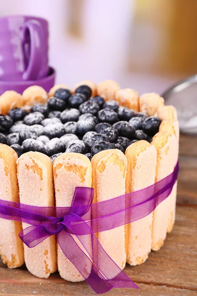 Tasty cake Charlotte with blueberries on wooden table, on light background — Stock Photo, Image