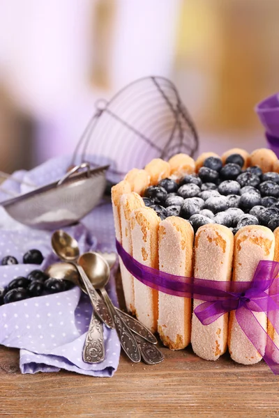 Tasty cake Charlotte with blueberries on wooden table, on light background — Stock Photo, Image