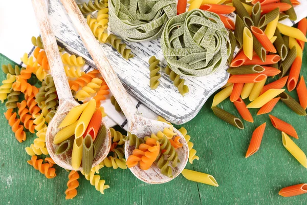 Pastas coloridas en cucharas de madera — Foto de Stock