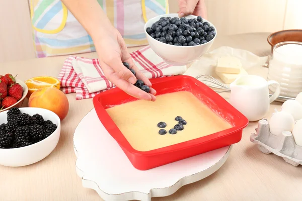 Hornear sabroso pastel e ingredientes para ello en la mesa en la cocina —  Fotos de Stock