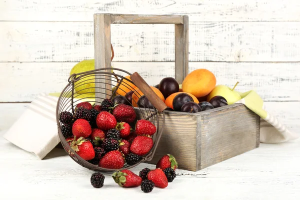 Ripe fruits and berries on table on wooden background — Stock Photo, Image