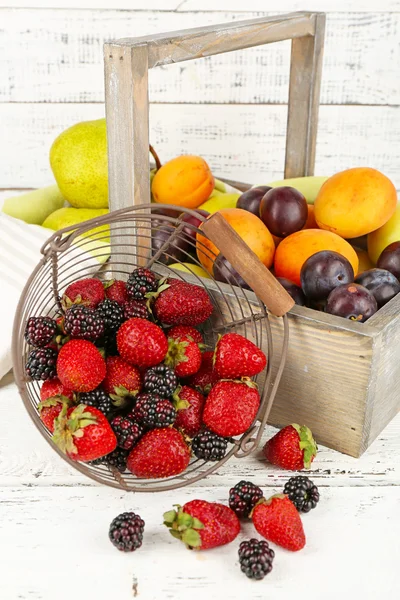 Ripe fruits and berries on table on wooden background — Stock Photo, Image
