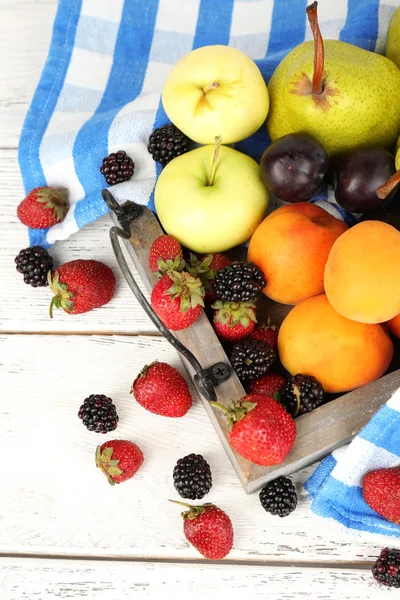 Dojrzałe owoce i jagody na drewnianej tacy na stole z bliska — Zdjęcie stockowe