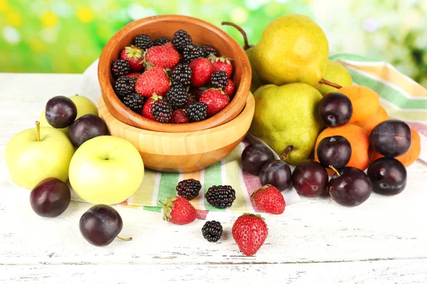 Frutas maduras y bayas sobre la mesa sobre fondo brillante — Foto de Stock