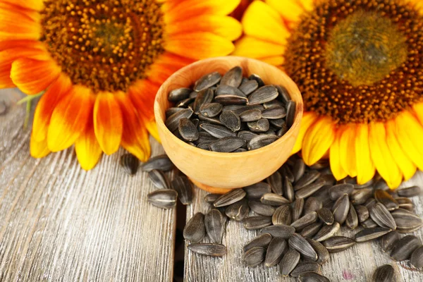 Zonnebloemen en zaden in kom — Stockfoto