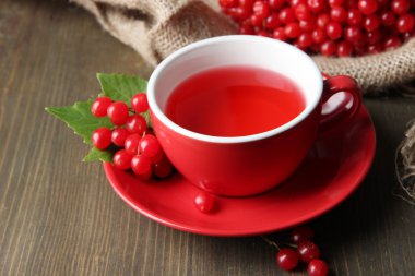 Bodegón con té de viburnum en servilleta de tela de saco, sobre fondo de madera