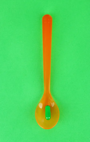 Plastic spoon with color pills — Stock Photo, Image