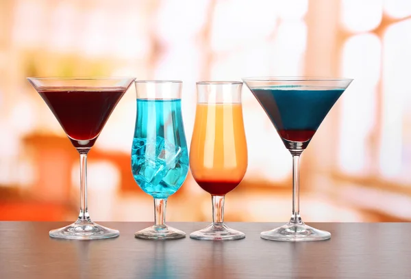Vários copos de bebidas diferentes no fundo brilhante — Fotografia de Stock