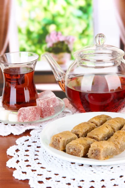 Süße Baklava auf Teller mit Tee auf dem Tisch im Zimmer — Stockfoto