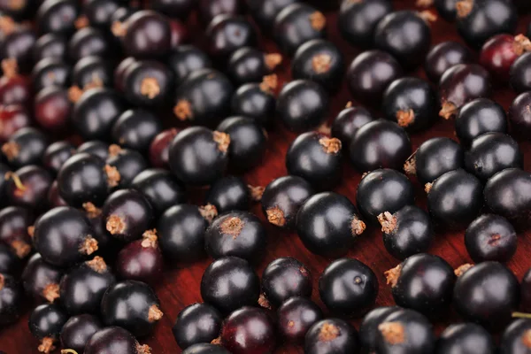 Färska svarta vinbär på trä bakgrund på nära håll — Stockfoto