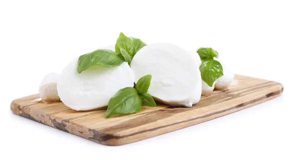 Schmackhafter Mozzarella mit Basilikum auf Holzbrett isoliert auf weiß — Stockfoto