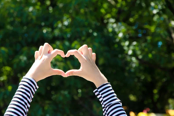 Ragazza che si tiene per mano a forma di cuore — Foto Stock