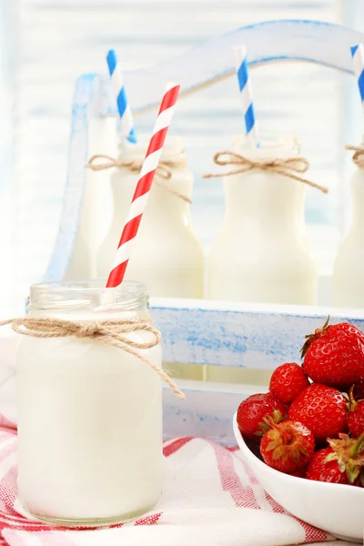 Milch in Flaschen mit Papierhalmen — Stockfoto
