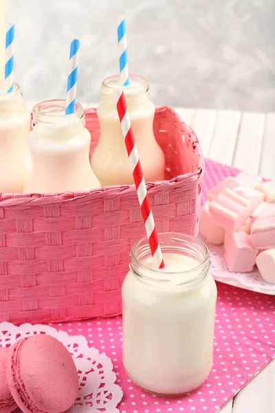 Melk in flessen met papier rietjes — Stockfoto