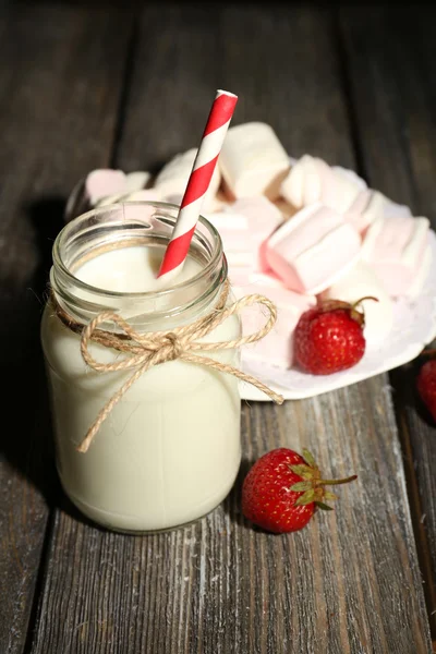 Lait en bouteilles avec des pailles de papier sur la table — Photo