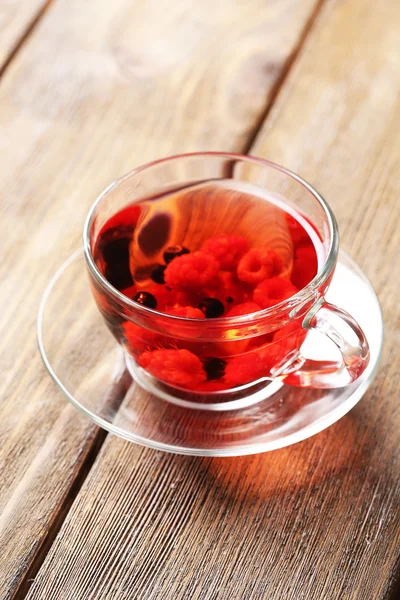 Τσάι φρούτων κόκκινο με άγρια μούρα στο γυαλί Κύπελλο, σε ξύλινο φόντο — Φωτογραφία Αρχείου