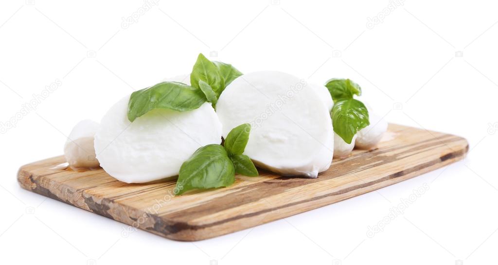 Tasty mozzarella with basil on wooden board isolated on white