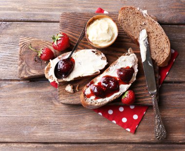 ahşap arka plan üzerinde ev yapımı tereyağı ve çilek reçel taze tost