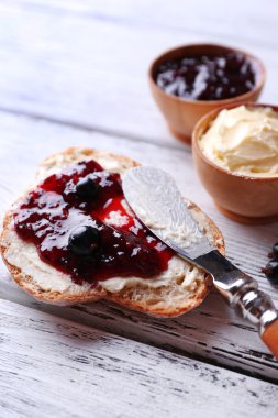 taze ekmek ile ev yapımı tereyağı ve blackcurrant jam hafif ahşap arka plan üzerinde