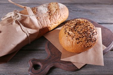 Kağıt, ahşap arka plan üzerinde sarılı taze pişmiş ekmek