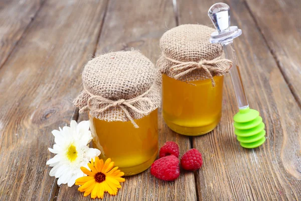 Kruik vol met heerlijke verse honing en wilde bloemen op houten tafel — Stockfoto