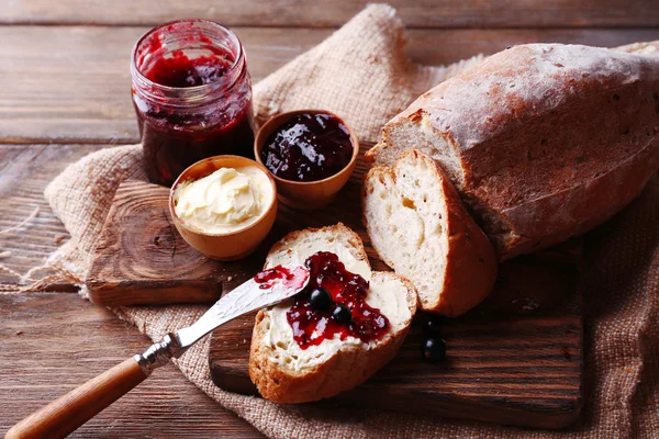 Taze ekmek ile ev yapımı tereyağı ve blackcurrant jam ahşap arka plan üzerinde — Stok fotoğraf