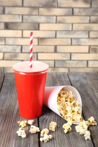 Popcorn on wooden table on wall background — Stock Photo, Image