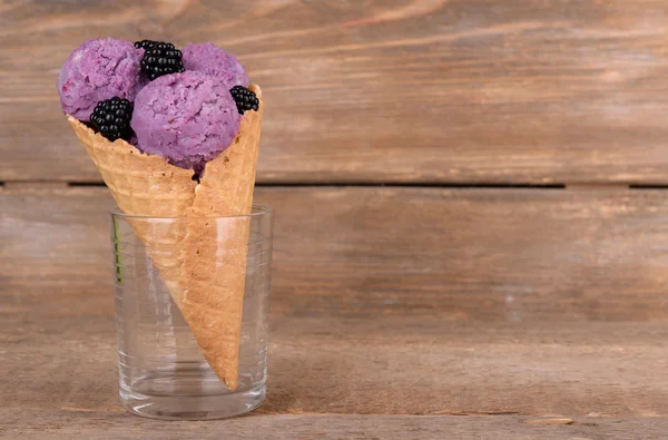 茶色の木製の背景にワッフル コーンで果実とおいしいアイスクリーム — ストック写真