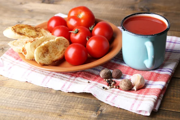 Homemade tomato juice in color mug, toasts and fresh tomatoes on wooden background — Stock Photo, Image