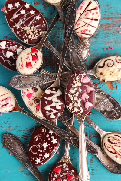Spoons with tasty chocolate for party on old blue wooden table — Stock Photo, Image