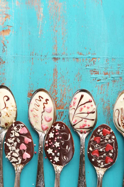 Löffel mit leckerer Schokolade zum Feiern auf altem blauen Holztisch — Stockfoto