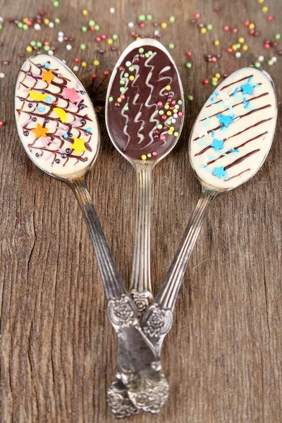 Cucharas con sabroso chocolate para fiesta en mesa de madera vieja — Foto de Stock