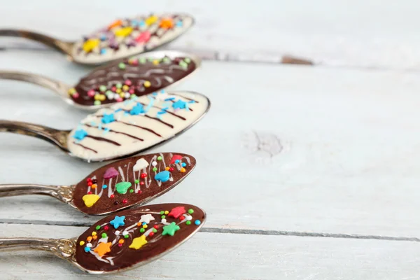 Löffel mit leckerer Schokolade zum Feiern auf altem Holztisch — Stockfoto