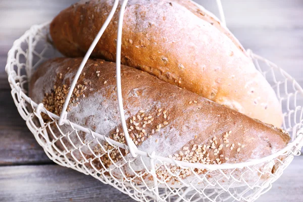 Pan recién horneado en cesta, sobre fondo de madera —  Fotos de Stock
