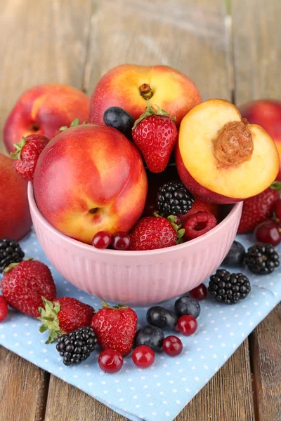 Персики і ягоди в мисці — стокове фото
