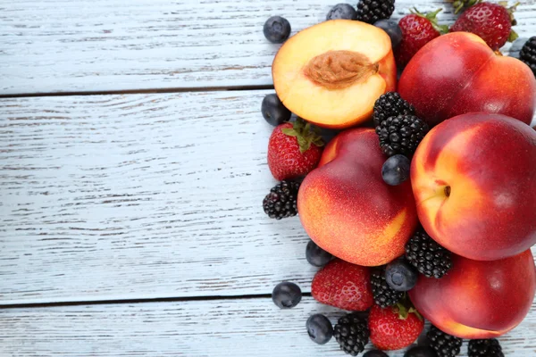 Peaches with berries on wooden table close-up — Stock Photo, Image