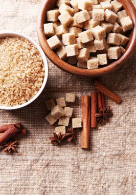 kahverengi şeker cubes ve kristal şeker, çul arka planda kasede baharat