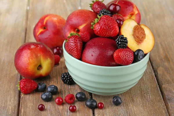 Peaches and berries in bowl — Stock Photo, Image