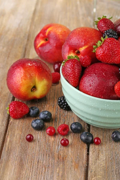 Pfirsiche und Beeren in Schüssel — Stockfoto