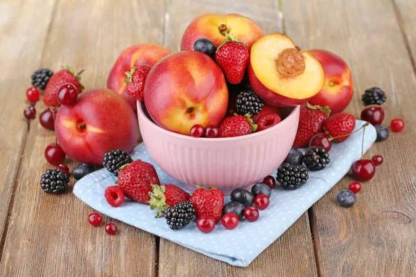 Peaches and berries in bowl — Stock Photo, Image