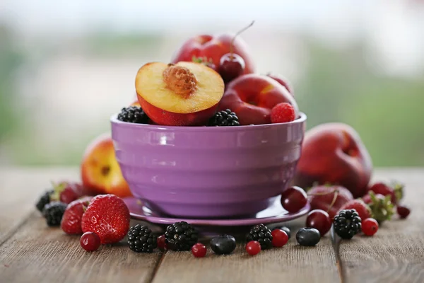 Peaches and berries in bowl — Stock Photo, Image