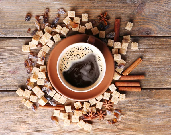 Azúcar moreno, especias y taza de café sobre fondo de madera — Foto de Stock