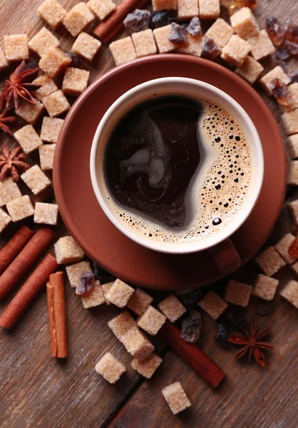 Azúcar moreno, especias y taza de café sobre fondo de madera — Foto de Stock