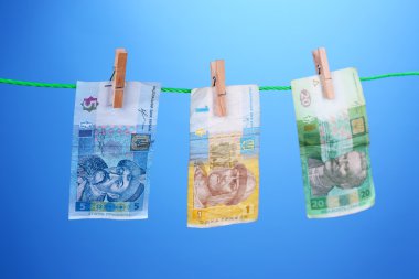 Ukraynalı hryvnia faturaları ipte asılı giysileri ile pim bağlı. Kara para aklama kavramı. Renk arka plan üzerinde