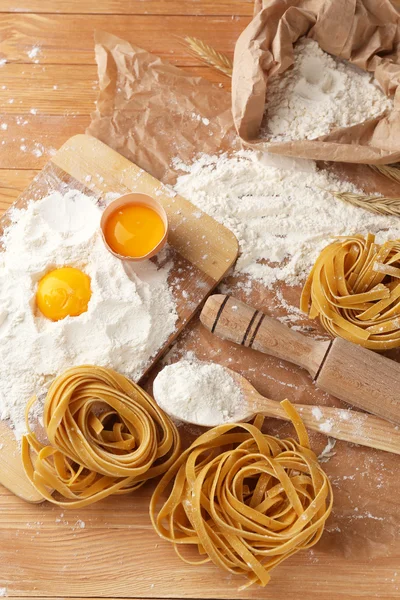 Natura morta con pasta cruda fatta in casa e ingredienti per la pasta — Foto Stock