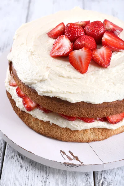 Heerlijke biscuit cake met aardbeien op tabel close-up — Stockfoto