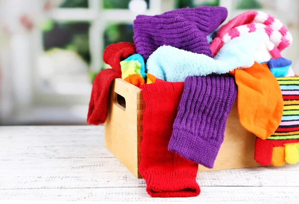 Calcetines multicolores en una caja sobre una mesa de madera frente a la ventana — Foto de Stock