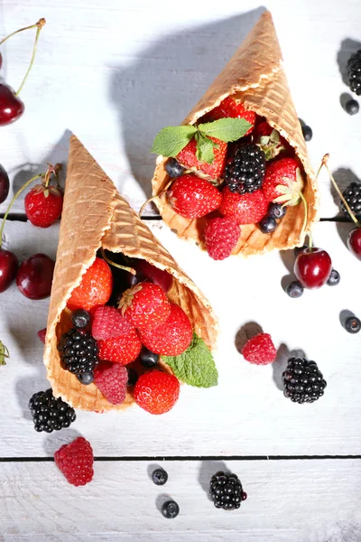 Спелые ягоды в сахарных конусах, на белом деревянном фоне — стоковое фото