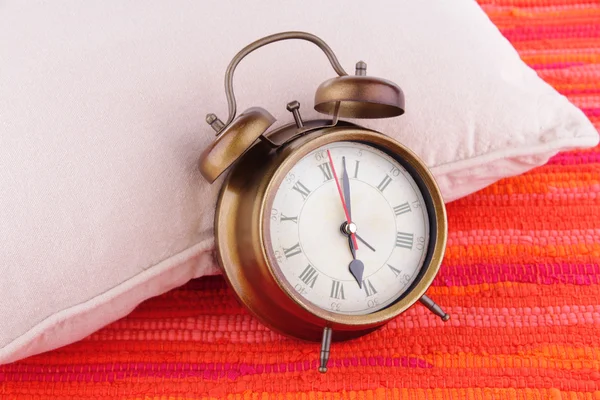 Metal clock with pillow — Stock Photo, Image